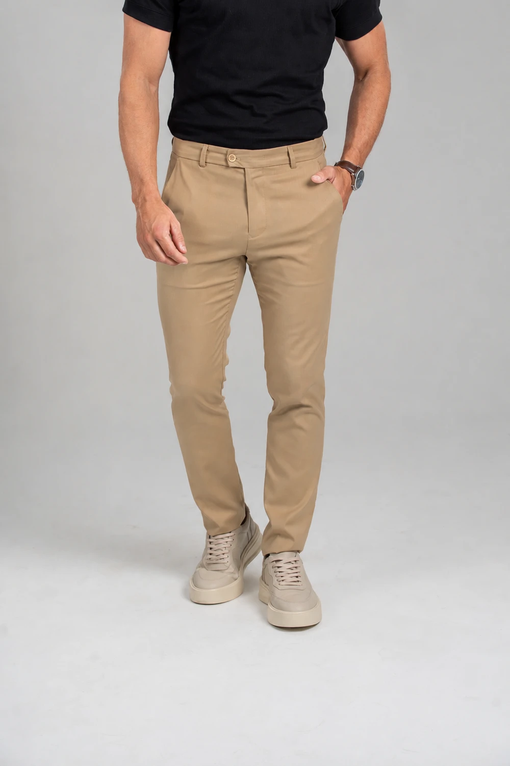Calça de alfaiataria bege com camiseta preta e tênis