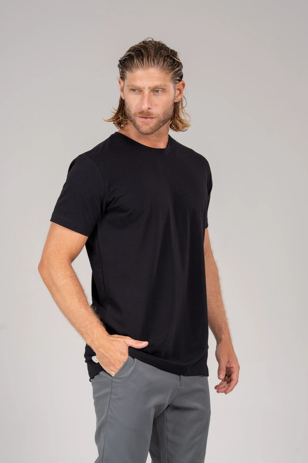 Homem com camiseta preta básica e calça cinza