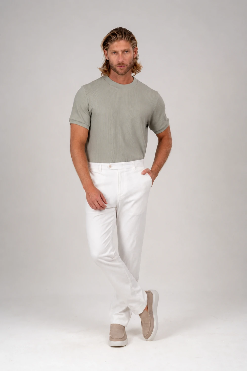 Homem com camiseta verde-sálvia e calça off-white