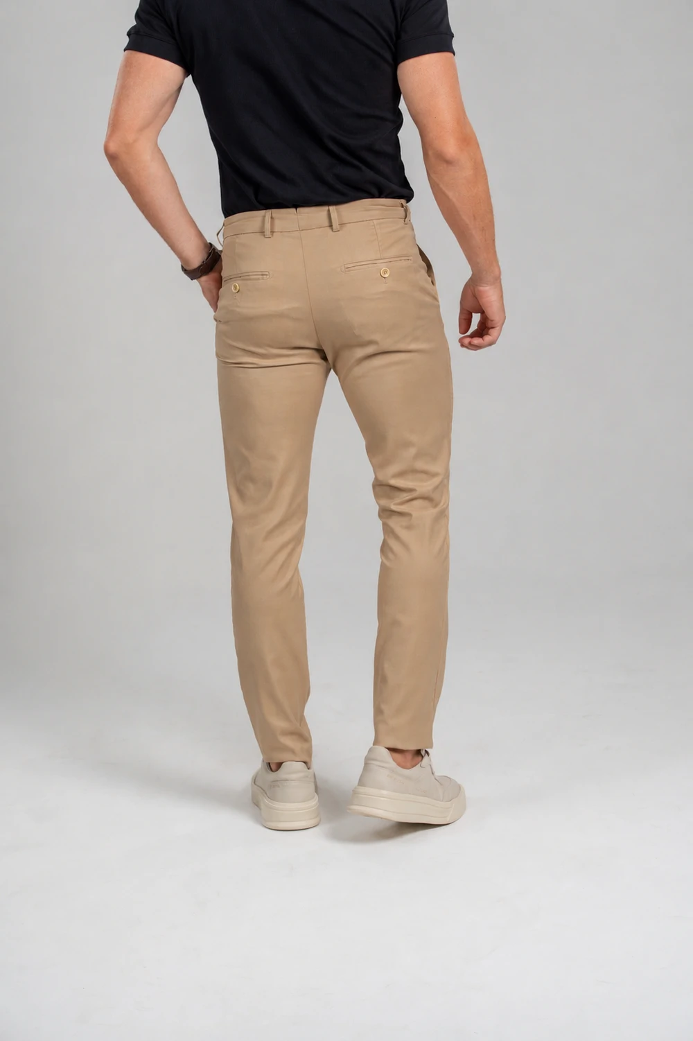Calça de alfaiataria caqui com camiseta preta e tênis