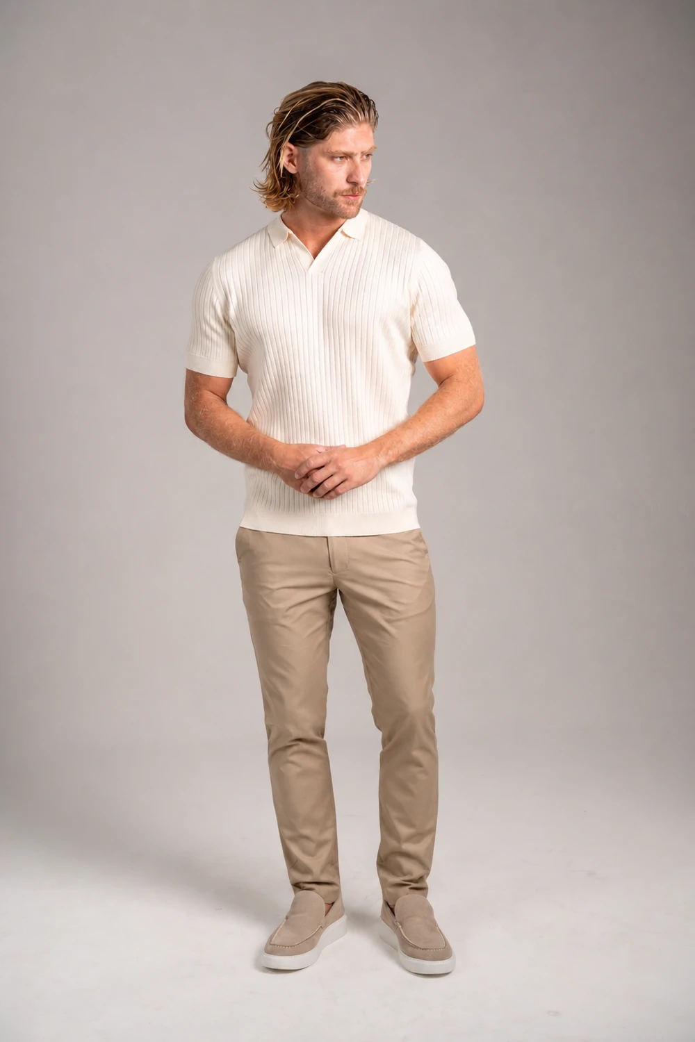 Homem com camisa polo de tricô off-white e calça caqui