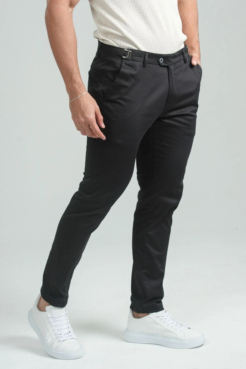 Calça de alfaiataria preta usada com camiseta branca e tênis branco