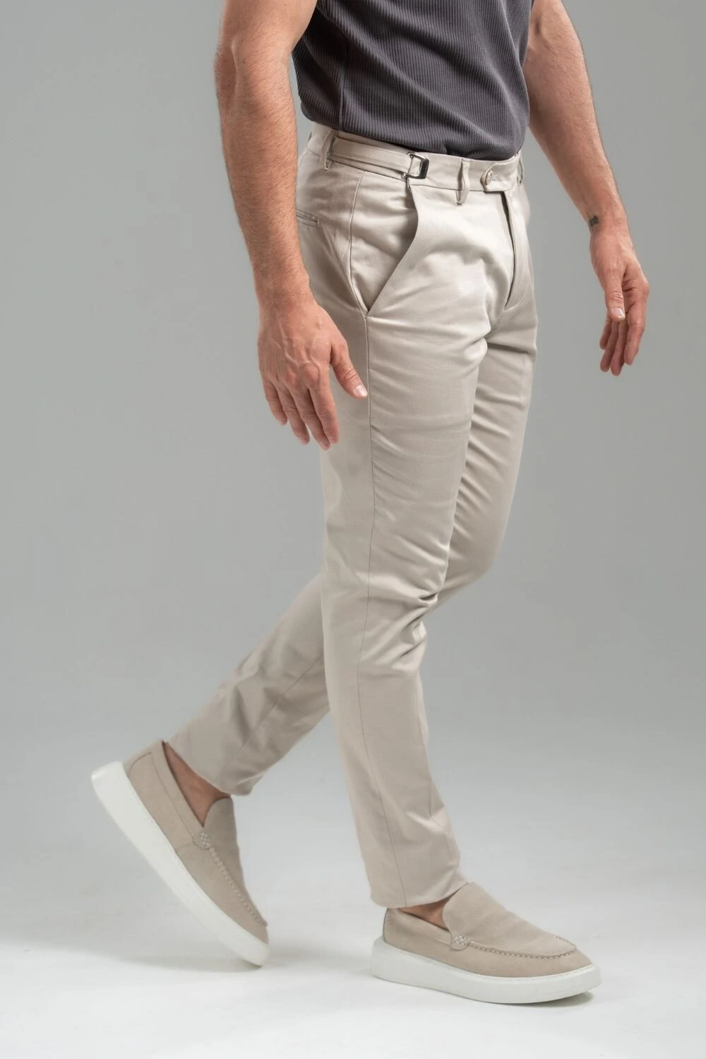 Calça de alfaiataria off-white com camiseta cinza e mocassim bege