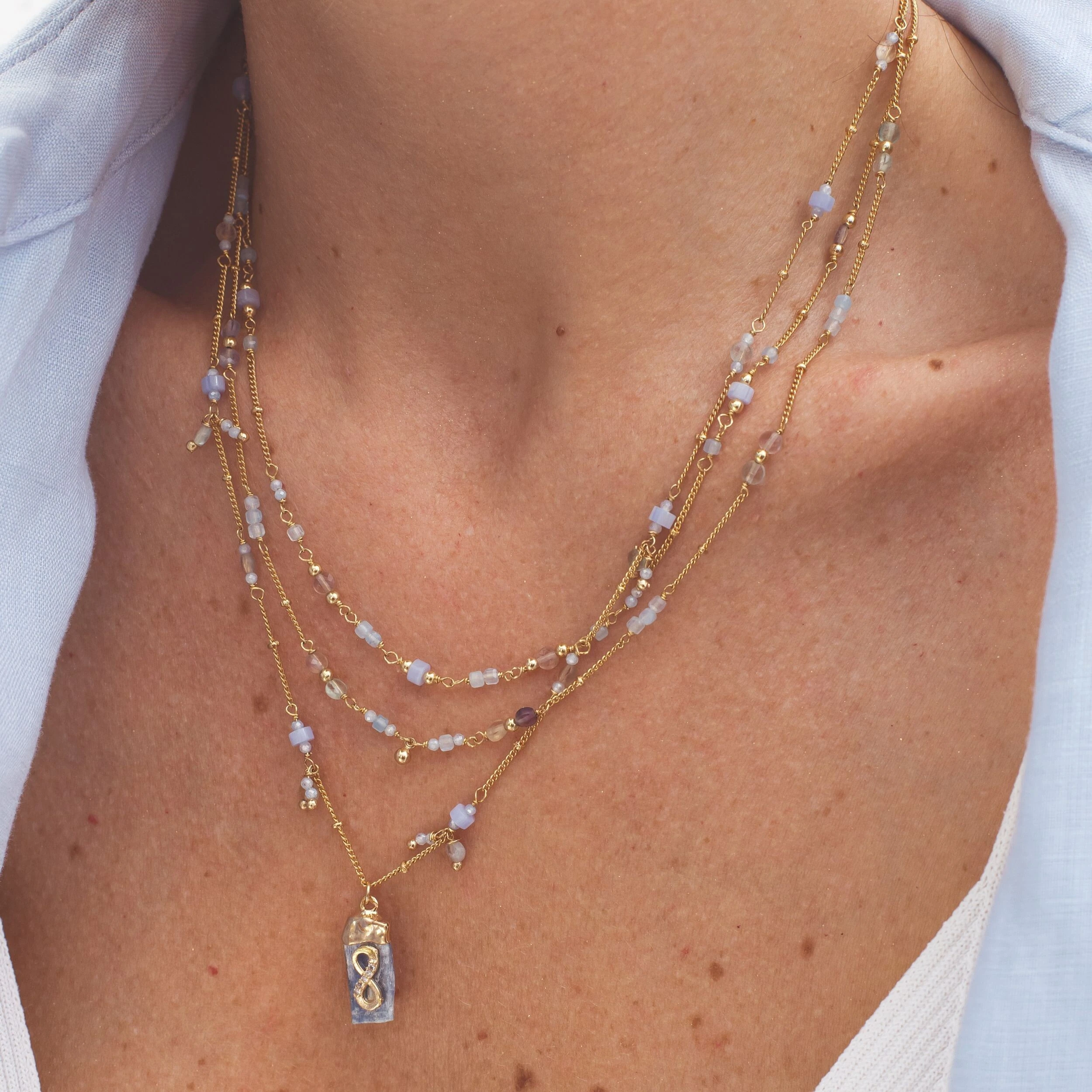 FotoColar dourado triplo pedra natural cianita azul com pingente pedra bruta com símbolo infinito