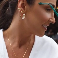 Piercing dourado com pérola shell, colunas com zircônia e folhas curvas