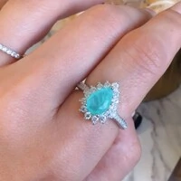 Anel com banho de ródio branco gota esmeralda colombiana entorno cravejado