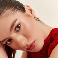 Brinco meia argola dourada gomos lisos e design vazado