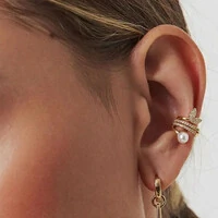 Piercing dourado com pérola shell, colunas com zircônia e folhas curvas