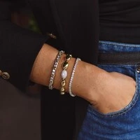 Pulseira bracelete ródio branco riviera com detalhe em x dourado