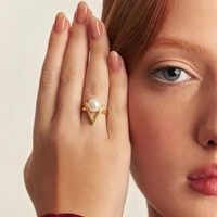 Anel dourado triangular, vazado, com pérola shell