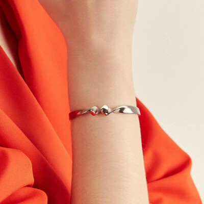 Foto Pulseira bracelete dourado liso com design torcido e curva suave