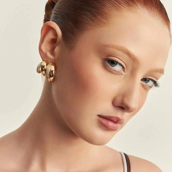 Brinco meia argola dourada linha lisa grossa e menor cravejada