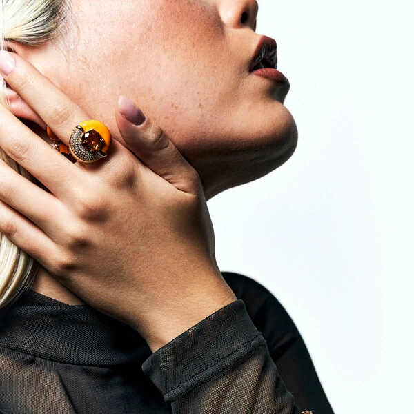 Anel dourado redondo meio cravejado e meio esmaltado laranja com cristal laranja