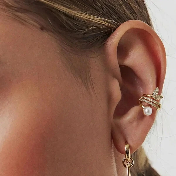 Piercing dourado com pérola shell, colunas com zircônia e folhas curvas