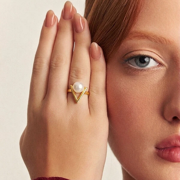 Anel dourado triangular, vazado, com pérola shell