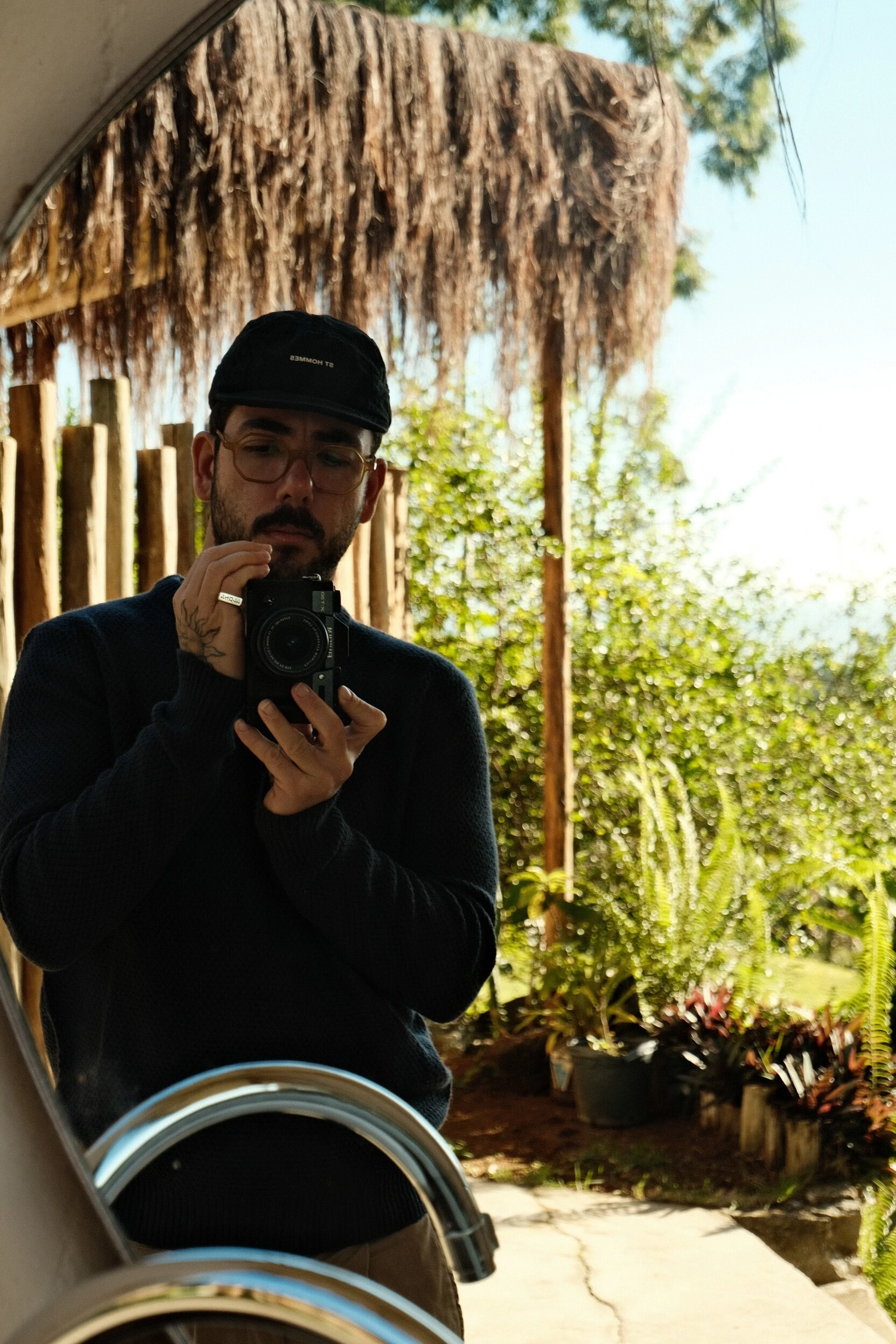 Murilo Lopes fotografando diante de um espelho em área cercada por vegetação