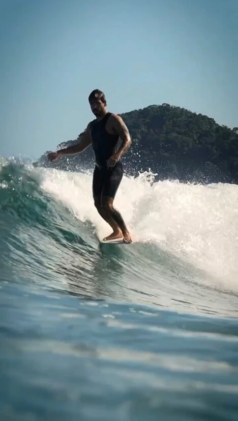 Murilo em pé na prancha durante uma onda