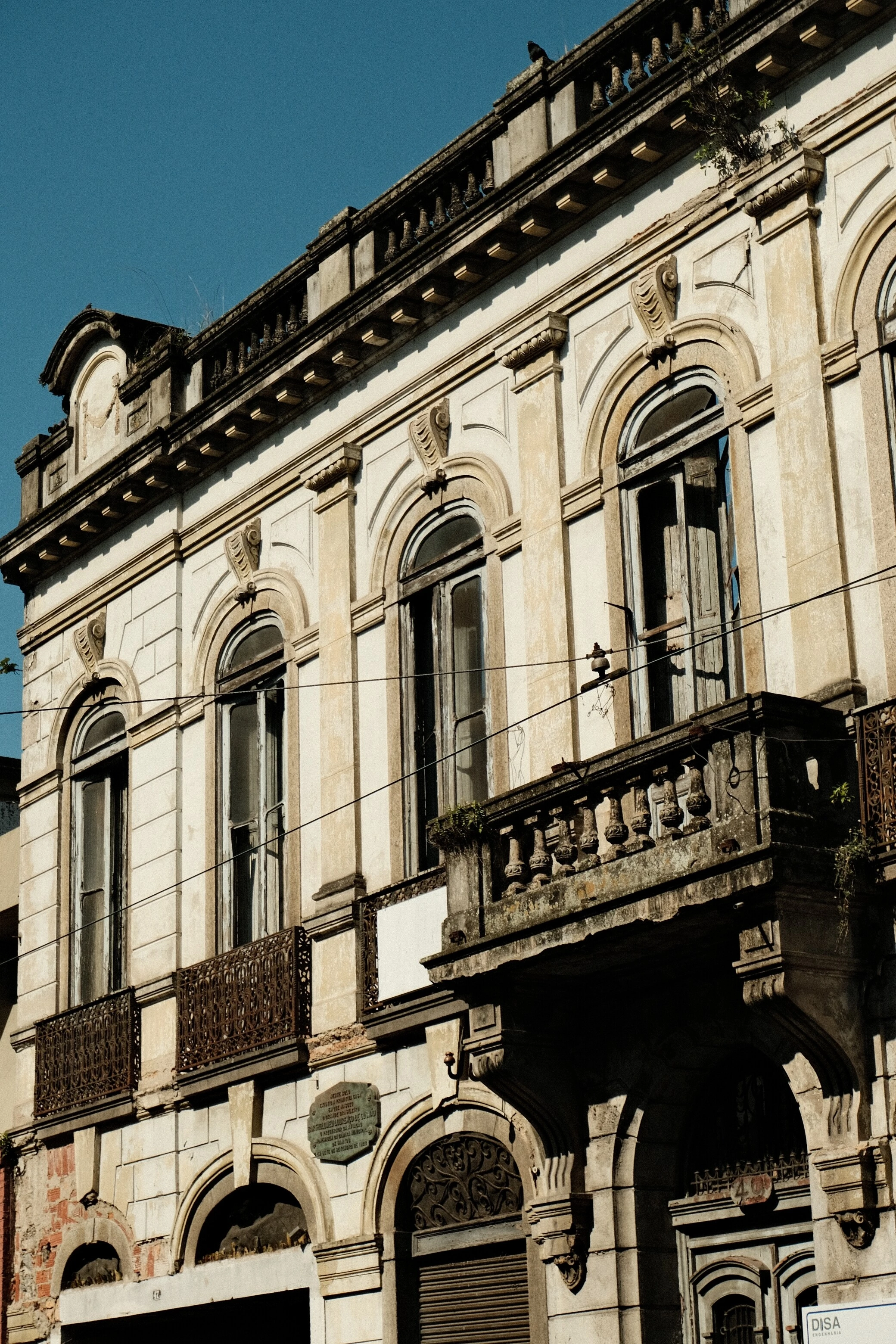 Fachada de prédio antigo, com detalhes ornamentados e textura desgastada pelo tempo