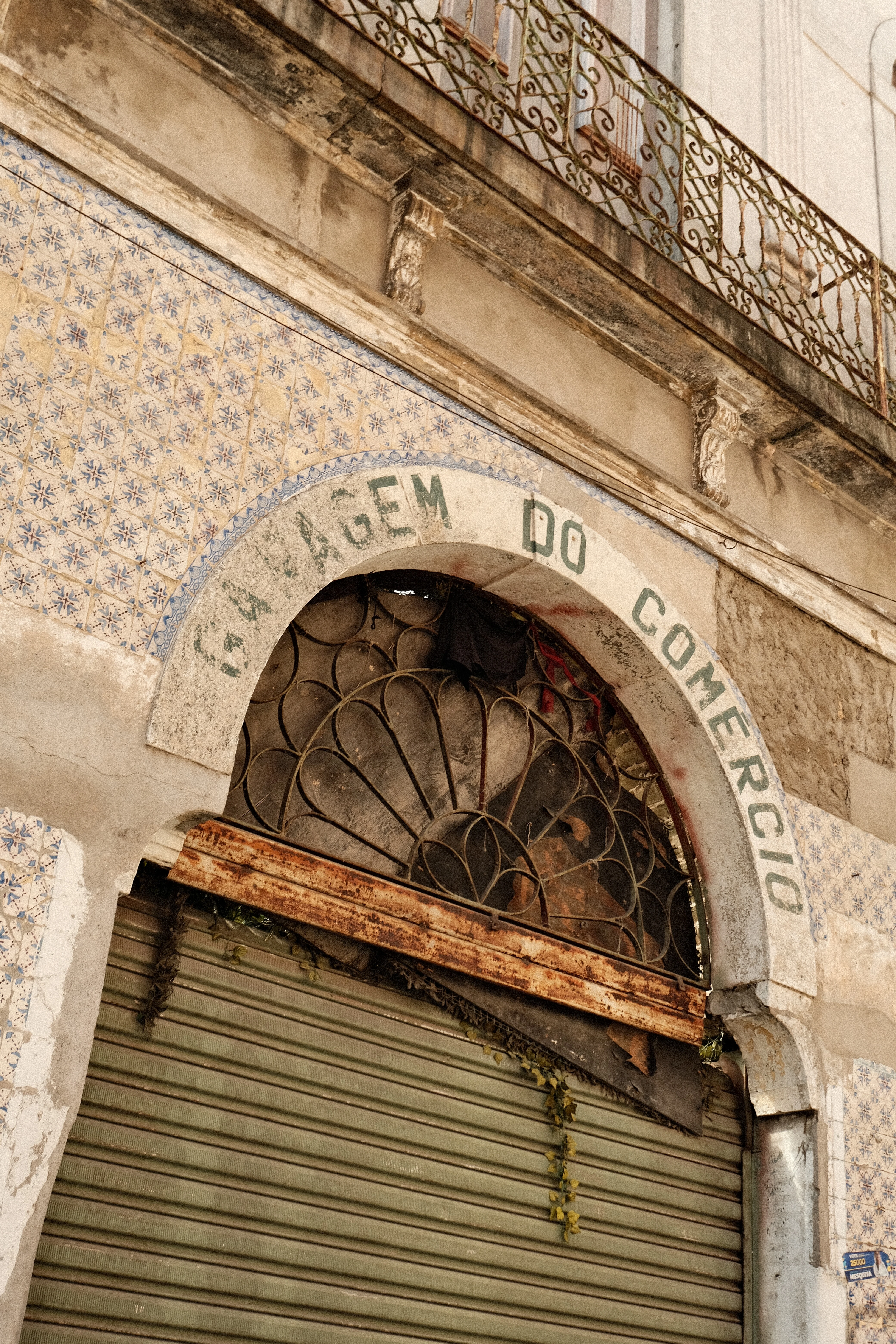 Arco de azulejos e sacada de ferro trabalhado em fachada antiga