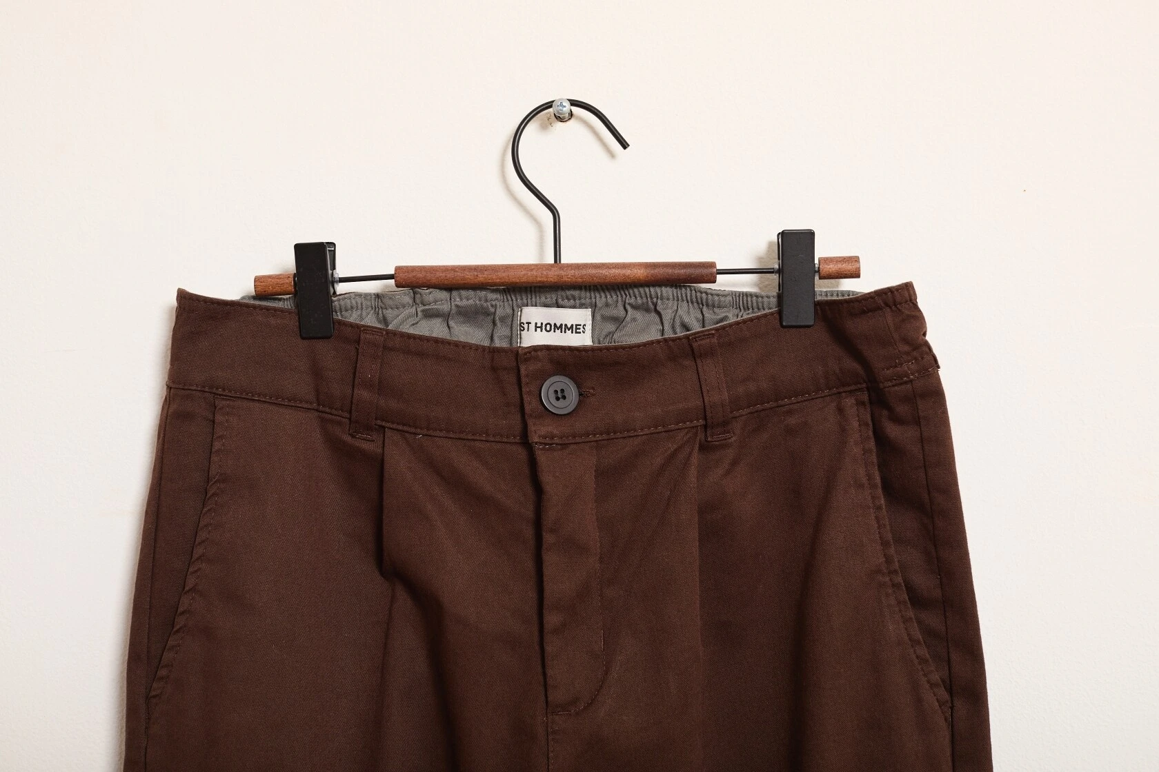 Detalhe do cós e botão da Calça Reta All Day Elastic Motion, pendurada em cabide